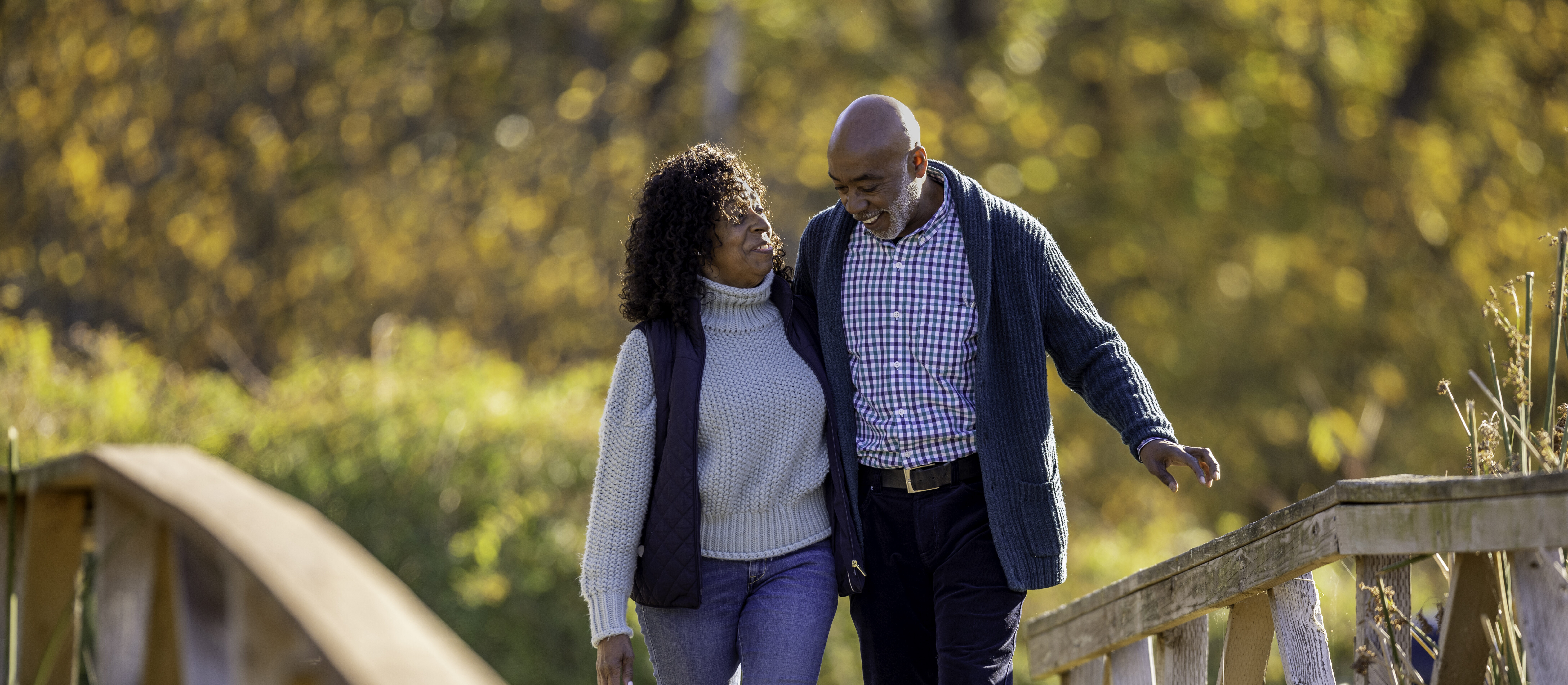 Couple in a Gorgeous Park Attractive African American couple enjoying each other’s company walking and talking in a park and enjoying coffee on their porch.